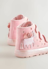 Rózsaszín szövet bokacsizma egyszarvú mintával, texturált díszítésekkel, csillagokkal és puha, bársonyos felülettel. Tépkedős pántokkal.