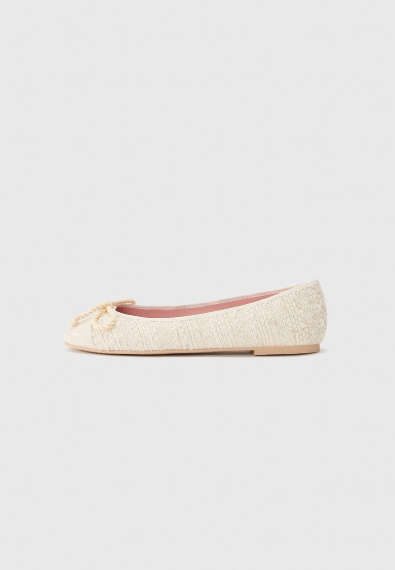 Ballet flat with a textured cream fabric upper, glossy cap toe, and rope detail at the front. Flat sole in a light tan color.
