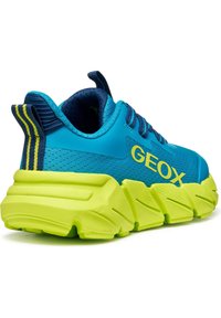 Scarpa athletic blu e gialla con tomaia in rete, suola neon spessa e strisce a contrasto. Presenta un marchio ben visibile sul lato.