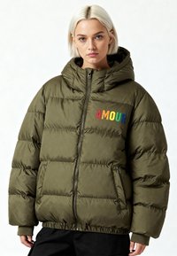 Doudoune matelassée vert olive avec capuche, dotée d'une fermeture éclair et d'une broderie colorée "AMOUR" sur la poitrine. Ourlet élastiqué.