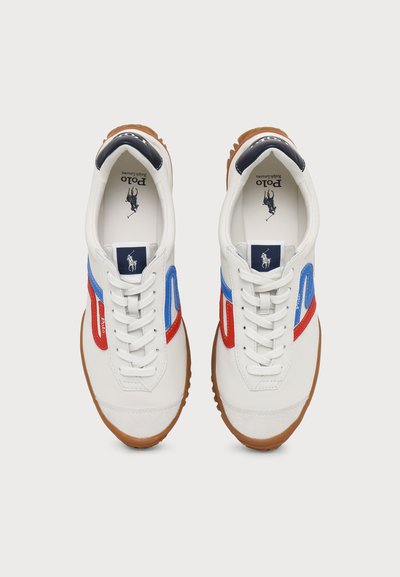 Ζευγάρι λευκά sneakers Polo Ralph Lauren με κόκκινες και μπλε πλευρικές ρίγες και καφέ λαστιχένιες σόλες, σε θέα από πάνω.