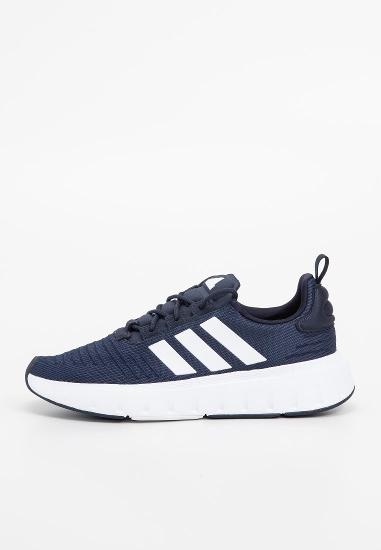 Marineblaue Adidas Sneakers mit weißen drei Streifen, dicker weißer Sohle, Strick-Obermaterial und Zuglasche an der Ferse, seitlich auf einem weißen Hintergrund dargestellt.