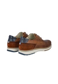 Zapatos de cuero marrón con un acabado texturizado y acentos en azul marino. Cuentan con una suela de color claro y un diseño con patrón en los lados.