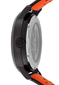 Cassa nera con retro trasparente, accompagnata da un cinturino in pelle arancione. Presenta una forma rotonda e una corona testurizzata per la regolazione.