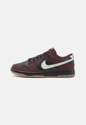 Nike Dunk Low -kengät mustalla päällisellä, viininpunaisilla mokkajäljitelmäkorostuksilla, valkoisella Swoosh-logolla ja kumipohjalla. Mustilla kengännauhoilla varustettuna.