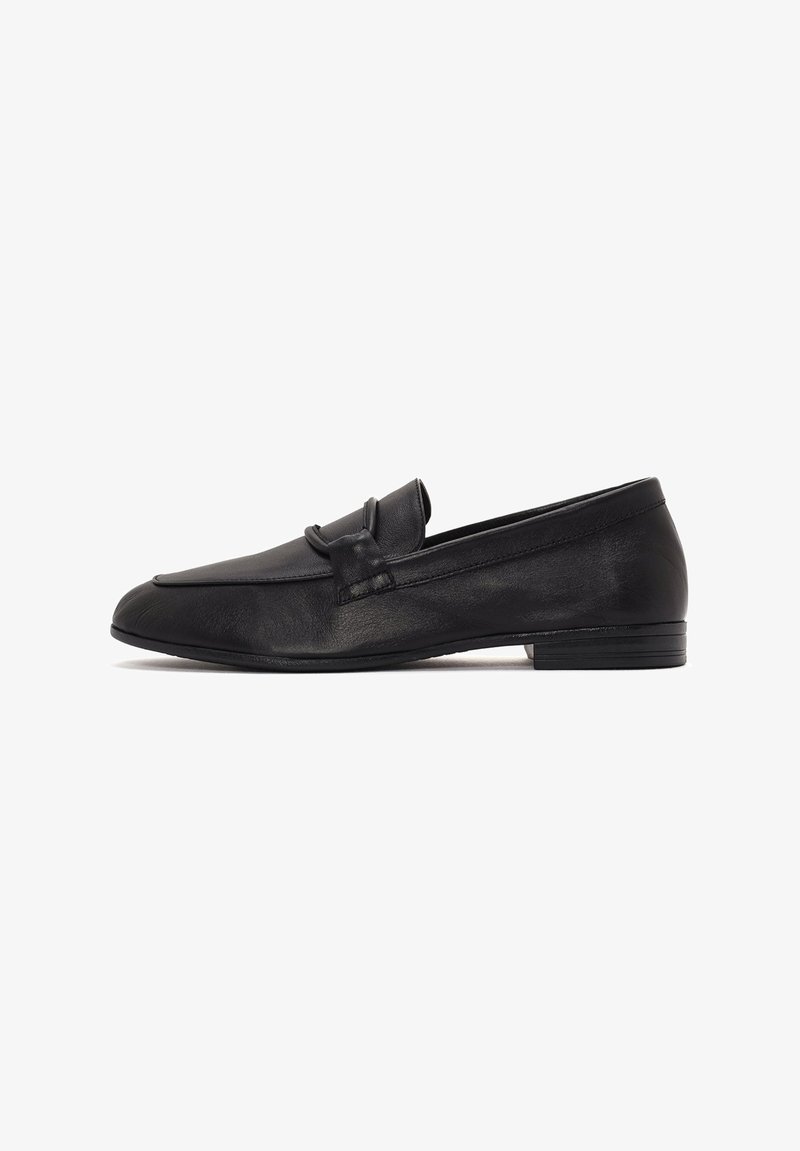 Loafers en cuir noir avec une couture surélevée et un accent de nœud décoratif. Présentent un petit talon empilé et une texture lisse.