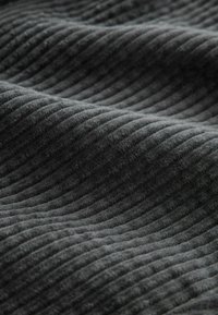 Dark gray ribbed fabric with soft, raised parallel ridges creating a textured, wavy surface pattern.