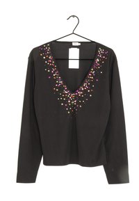 Svart långärmad topp med djup V-ringning, prydd med färgglada paljetter som hänger ner från halsringningen.