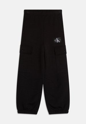 Schwarze Cargohosen mit elastischen Bündchen, Klappentaschen an den Oberschenkeln und einem Calvin Klein Logo-Aufnäher am oberen linken Oberschenkel.