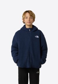 Φούτερ με φερμουάρ μπροστά σε σκούρο μπλε χρώμα, σε μεγάλο μέγεθος, με δύο μπροστινές τσέπες και λογότυπο στο αριστερό στήθος. Μαλακό, υφασμάτινο με υφή.