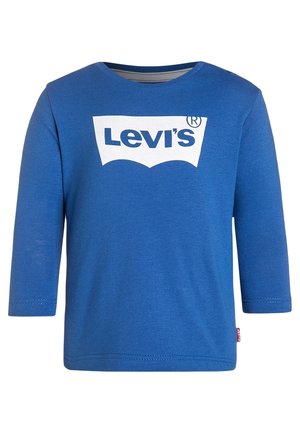Niebieska koszulka z długim rękawem dla malucha z białym logo Levi’s na środku klatki piersiowej i małą czerwoną metką Levi’s na lewym bocznym szwie.