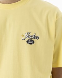 Gul bomull t-skjorte med rund hals og korte ermer. Sentrert grafisk tekst "Jacker" med stjerne og "Forever Hustling" under.