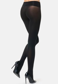 Collant neri opachi con una cintura ampia e liscia, abbinati a scarpe con tacco alto nere e lucide; texture elegante e design aderente.