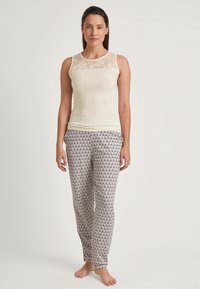 Crème tanktop met kanten overlay, gecombineerd met gebloemde grijze pyjamabroek met een gegolfd ontwerp. Zachte stoftextuur, casual pasvorm.