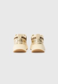Sneakers with a gold metallic and leopard print accent, cream upper, textured sole, and pull tab at the heel for easy wear.