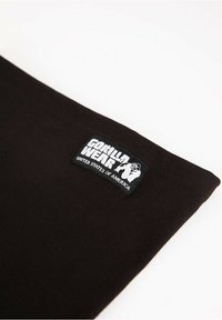 Black cotton clothing item with a rectangular label. The label features "GORILLA WEAR" and an illustration of a gorilla, with text reading "UNITED STATES OF AMERICA."