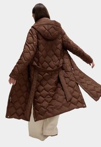 Brun quiltet lang jakke med hætte, featuring et diamantmønster, åben front, justerbart bælte og lynlåslommer på siden.