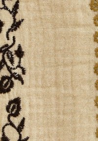 Beige fabric with black floral embroidery on one side and brown accents. The texture is woven, with visible thread patterns and depth.