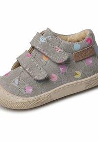 Grijze suède schoen met bloemmotieven in roze, blauw en geel. Voorzien van twee klittenbandsluitingen en een beige rubberen zool met textuur voor grip.