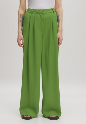 Wide-leg trousers made of smooth, bright green fabric, featuring a high waist, front pleats, and a button closure.