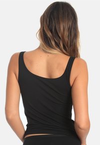 Black sleeveless tank top made of soft, stretchy fabric, featuring a rounded neckline and a fitted silhouette. No visible patterns or accents.