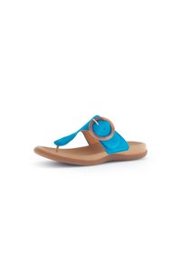 Sandalia de tiras de ante azul con un acento circular en tono marrón, suela acolchada y un diseño blando y flexible. Ideal para uso casual y comodidad.