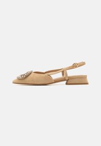 Bēša zamšādas slingback kurpes ar norādītu purngalu, dekorētas ar lielu dārgakmens detaļu un zemu, kvadrātveida papēdi. Regulējama potītes siksna.
