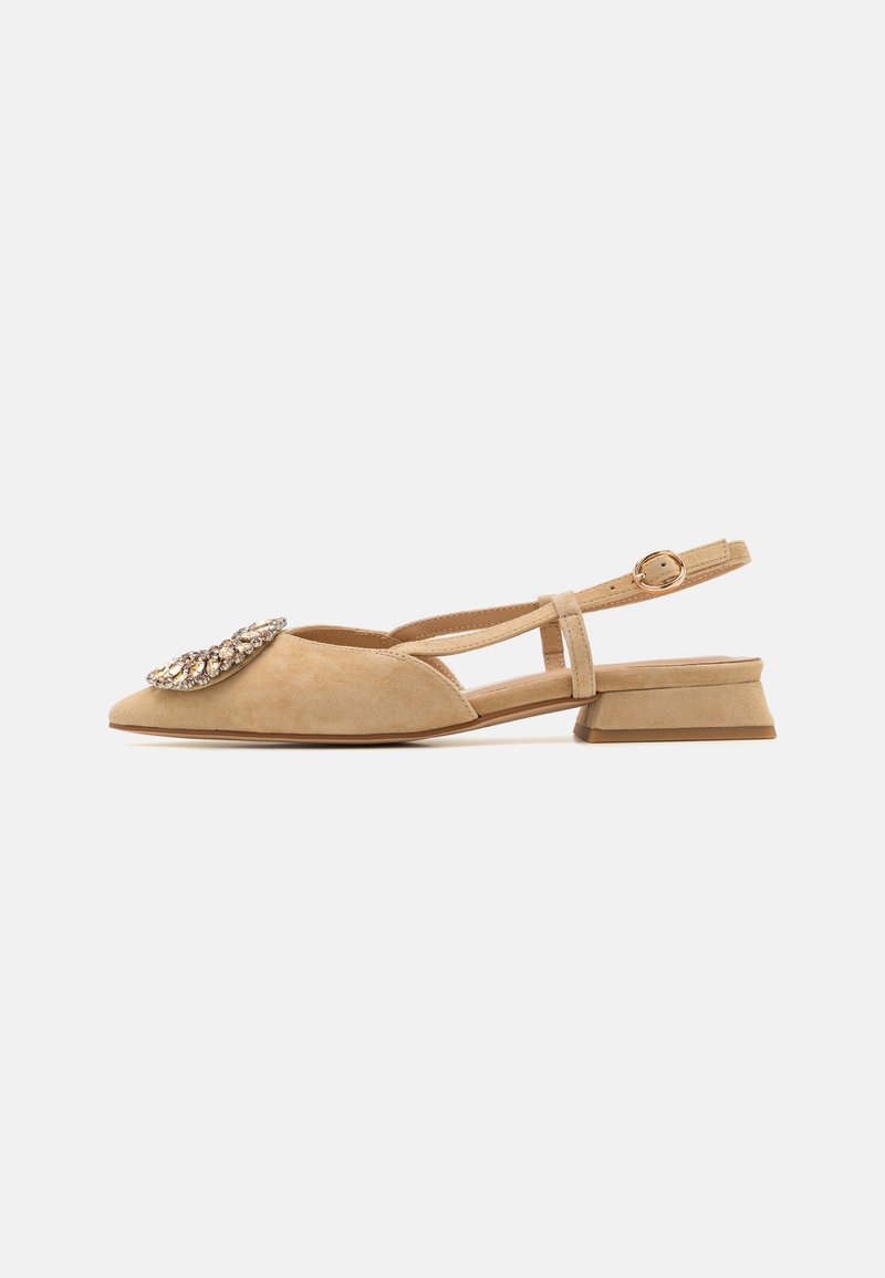 Bēša zamšādas slingback kurpes ar norādītu purngalu, dekorētas ar lielu dārgakmens detaļu un zemu, kvadrātveida papēdi. Regulējama potītes siksna.