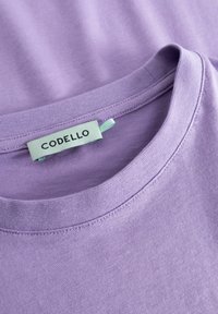 Lila T-shirt, van katoen, ronde hals, zachte textuur, met het 'CODELLO' label en teal accentstiksels.