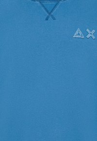 Sweatshirt azzurro chiaro realizzato in morbido tessuto, con un piccolo logo ricamato nell'angolo in alto a sinistra. Il collo presenta dettagli di punto croce.