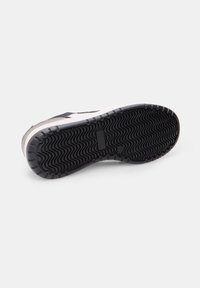 Fekete sneaker talp, textúrált cikk-cakk mintával, megerősített sarokkal és lapos, fehér középtalppal. Tartós gumi anyag.