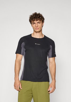 Schwarzes Sportshirt mit kurzen Ärmeln und grauen Seitenteilen. Verfügt über einen runden Halsausschnitt und ein Branding auf der Brust. Aus Baumwoll-Mischmaterial.
