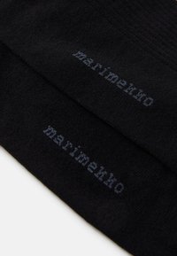 Calzini neri con texture a costine e dettagli del logo in grigio scuro. Presentano un design classico e un materiale morbido e elasticizzato.
