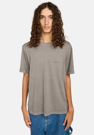 Szary t-shirt z okrągłym dekoltem, wykonany z miękkiego materiału, z krótkimi rękawami. Posiada małe logo na piersi oraz luźny, prosty krój.