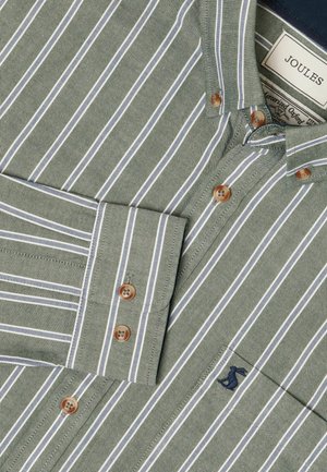 Green striped shirt with white stripes, featuring brown buttons, a pointed collar, and a small navy logo on the pocket.