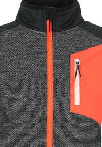 Veste zippée noire et grise en tissu texturé, avec une touche d'orange vif et une poche zippée sur la poitrine.