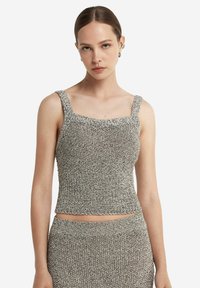 Grå stickad kort topp med fyrkantig halsringning och breda axelband, med en texturerad tyg och en figurnära silhuett, kombinerad med en matchande bottendel.