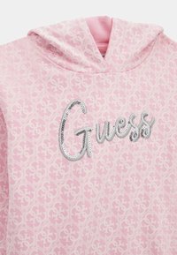 VILÁGOS RÓZSASZÍN KAPUCNIS PULÓVER, MELYNEK MINTÁS TEXTÚRÁJA VAN, EZÜST FOLYÓ KÖVEKKEL DÍSZÍTETT "GUESS" LOGÓVAL ÉS HÚZÓZSINÓVAL RENDELKEZIK. SIMA SZÖRZETŰ KIVITELEZÉS.