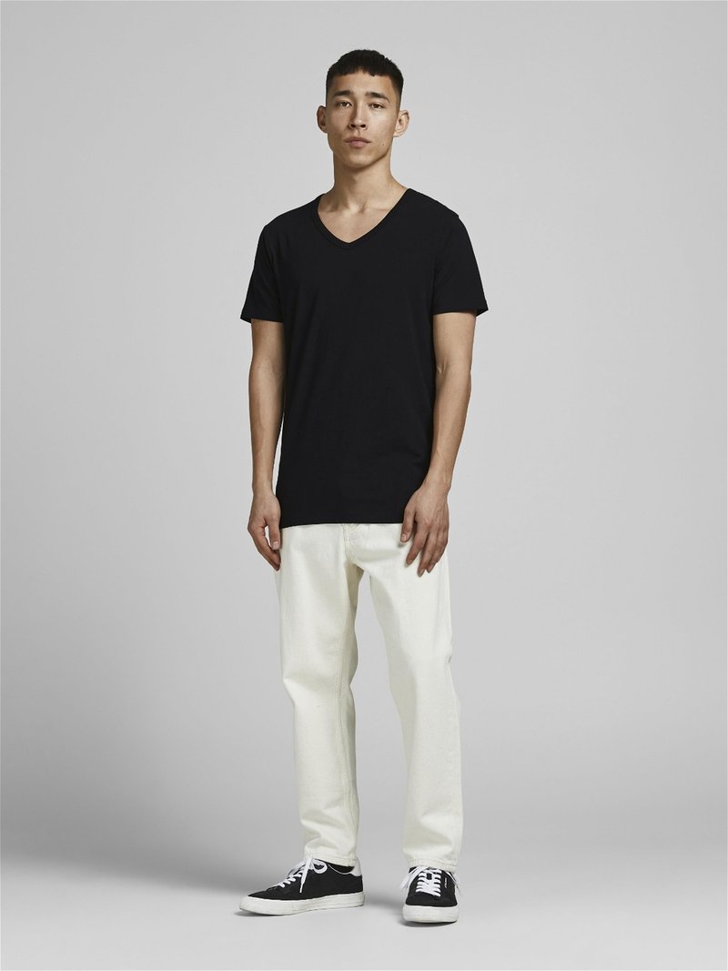 T-shirt noir à col en V, jeans blancs, baskets noires avec semelles blanches. Design minimaliste, coupe décontractée, tissu lisse et sans motifs visibles.