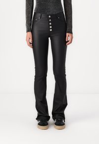 Pantalon flare en similicuir noir à taille haute, doté d'une fermeture à cinq boutons à l'avant, de passants pour ceinture et d'une texture lisse et brillante.