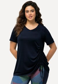 Top blu navy a maniche corte con scollo a V, caratterizzato da dettagli arricciati su un lato per aggiungere texture e una vestibilità rilassata.