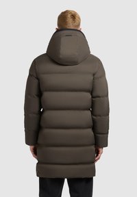 Abrigo acolchado marrón con una gran capucha, que presenta un diseño acolchado y puños de canalé. De longitud media con un acabado liso y mate.