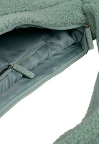 Zielona torba z polaru z pikowaną podszewką, podwójnymi zamkami błyskawicznymi z logo KUBOTA oraz miękkim, teksturowanym wykończeniem.
