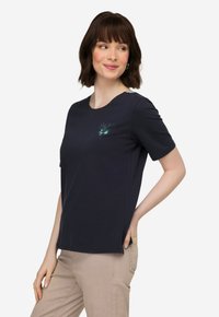 Marineblauwe T-shirt met korte mouwen en ronde hals, voorzien van een klein meerkleurig gedrukt ontwerp op de borst, gemaakt van een zachte katoenmix.