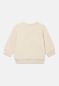 Φούτερ από βαμβάκι σε ανοιχτό μπεζ χρώμα με ριμπ λαιμόκοψη και μανσέτες. Έχει μακριά μανίκια και χαλαρή εφαρμογή, χωρίς ορατά γραφικά ή μοτίβα.