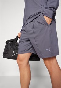 Puma sportshorts i mørkegrå stof med elastisk talje, sidelommer og et diskret logo på benet.