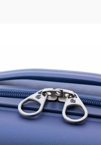 Cremallera de maleta azul con tiradores metálicos plateados dobles, con un agarre de goma texturizada y dientes de nylon azul, colocada sobre una superficie lisa.