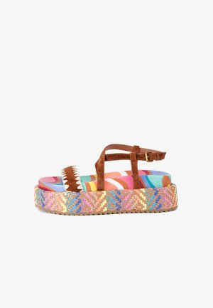 Sandalo platform in suede marrone con suola intrecciata multicolore, dotato di un design astratto colorato sulla soletta e cuciture decorative bianche.