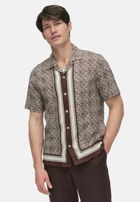 Short-sleeve button-up shirt featuring a brown and cream diamond pattern, with a contrasting vertical panel and a relaxed fit.