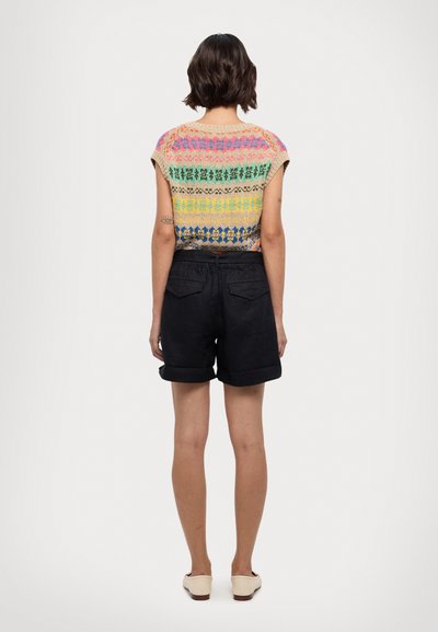 Top tricotat cu modele orizontale multicolore; mâneci scurte. Asortat cu pantaloni scurți negri și pantofi slip-on de o culoare deschisă. Stil casual clasic.